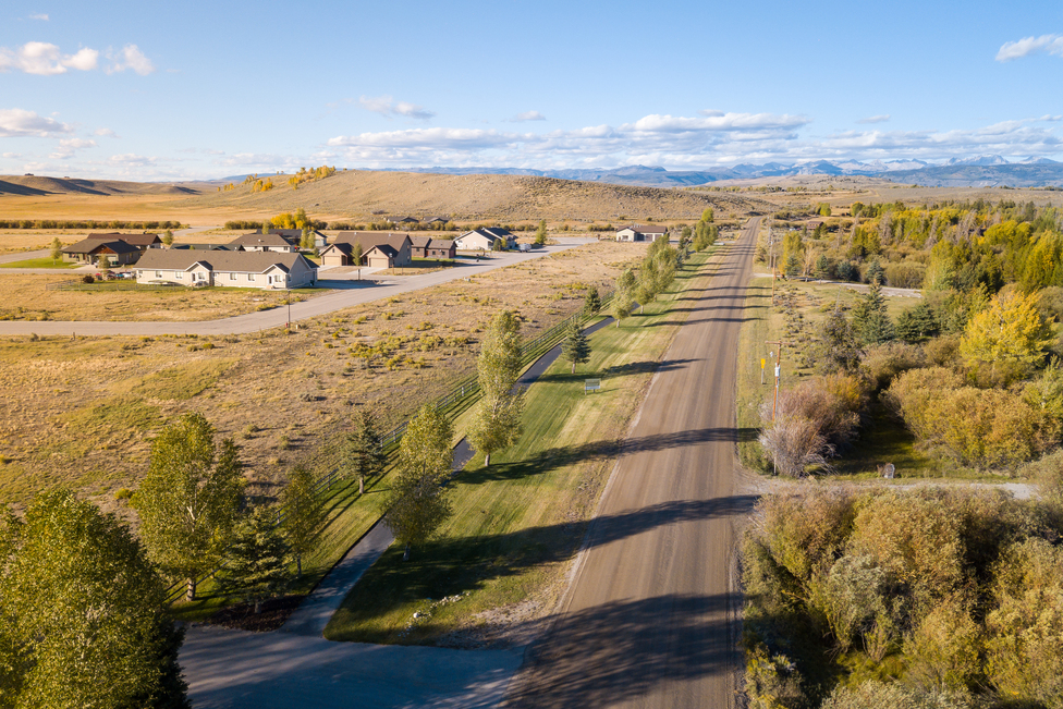 Aerial view of Split Diamond Meadows community road with homes and fall foliage